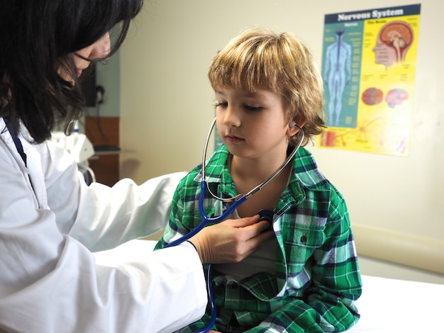 Photo gratuite médecin examinant un enfant avec un stéthoscope dans un hôpital