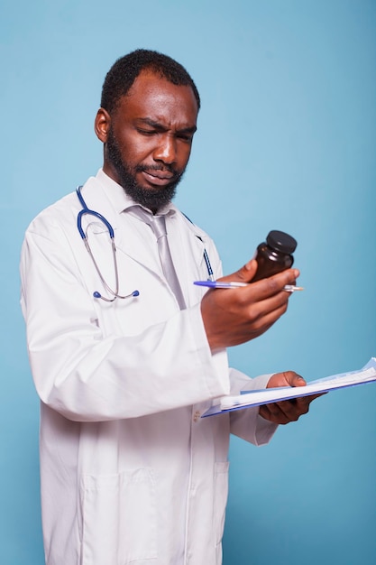 Photo gratuite le médecin examine attentivement le flacon de pilules.