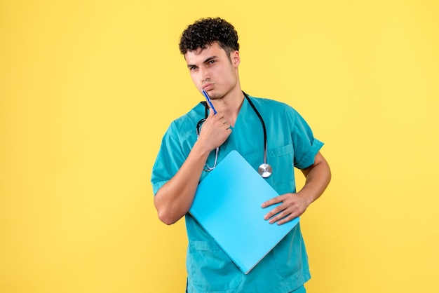 Médecin de face, le médecin avec dossier pense à ses patients atteints de COVID-