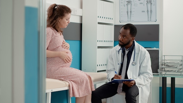 Médecin généraliste assistant à la consultation et prenant des notes