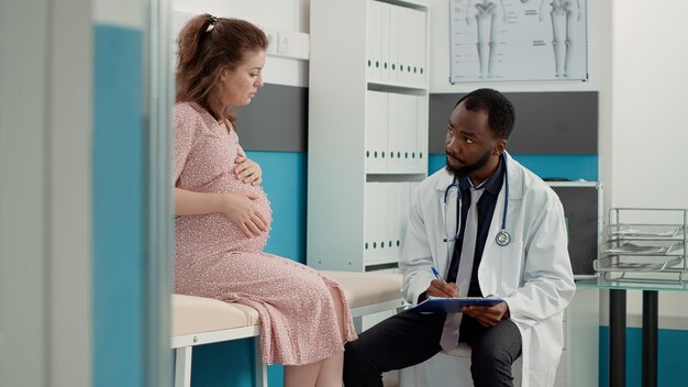 Médecin généraliste assistant à la consultation et prenant des notes