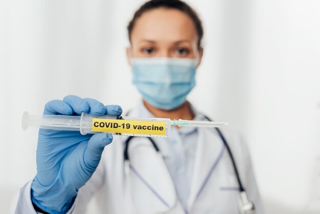 Médecin de gros plan tenant le vaccin covid19