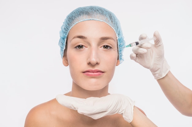 Médecin injectant dans le visage de la femme