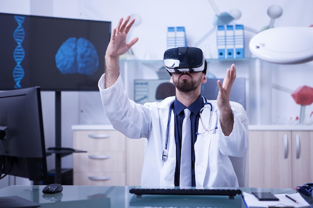 Médecin intelligent portant des lunettes de réalité virtuelle dans un bureau de clinique moderne. docteur avec stéthoscope.