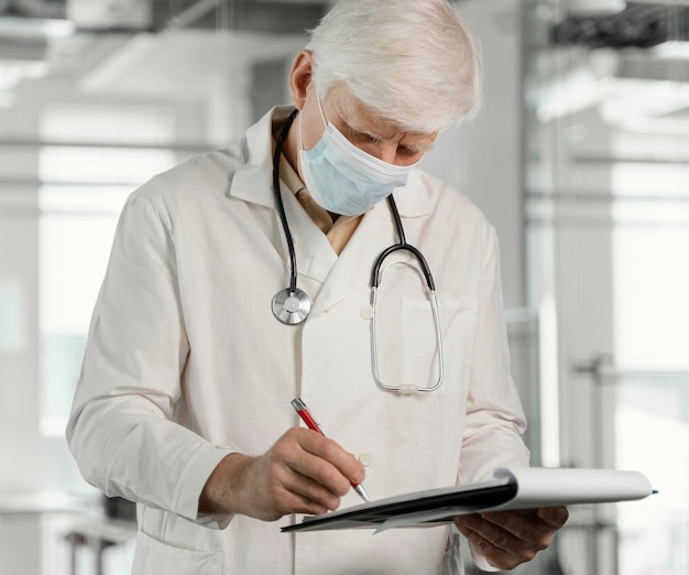 Médecin avec masque médical vérifiant ses notes