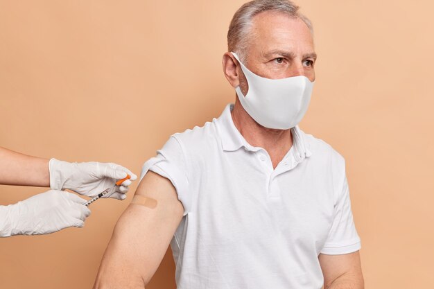 Photo gratuite un médecin méconnaissable fait vacciner un homme âgé