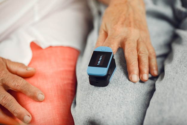 Le médecin met un moniteur de fréquence cardiaque sur un doigt du patient. L'homme tient la main de la femme.