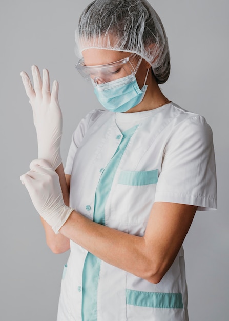 Photo gratuite médecin mettant des gants chirurgicaux