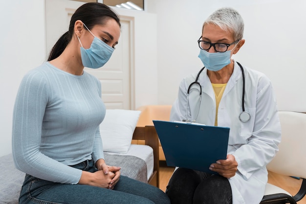 Médecin montrant un presse-papiers à un patient