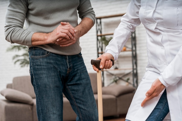 Médecin montrant à son patient comment utiliser des béquilles