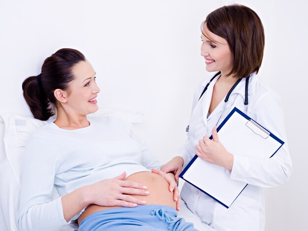 Médecin parle avec la femme enceinte à la clinique