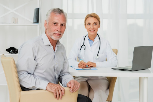 Médecin et patient regardant la caméra