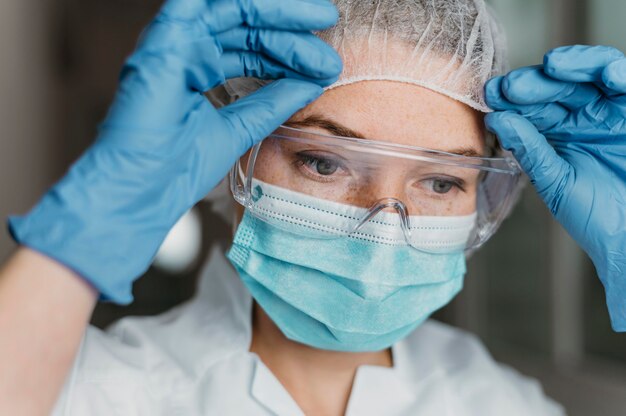 Médecin portant un masque facial et des lunettes de protection