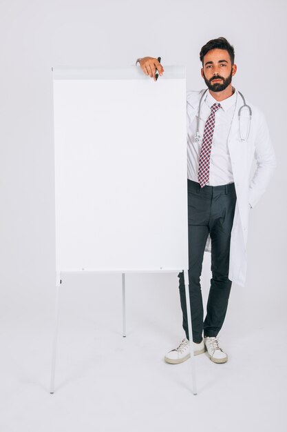 Médecin posant avec le tableau blanc