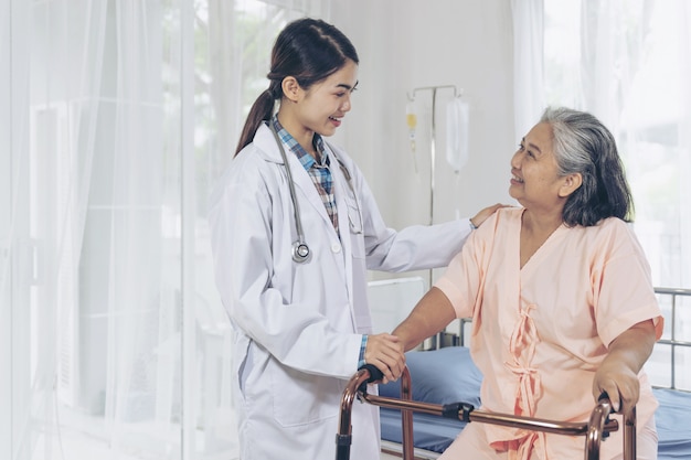 Le médecin prend bien soin des patients âgés dans les lits d'hôpital, les patients se sentent heureux - concept médical et de soins de santé