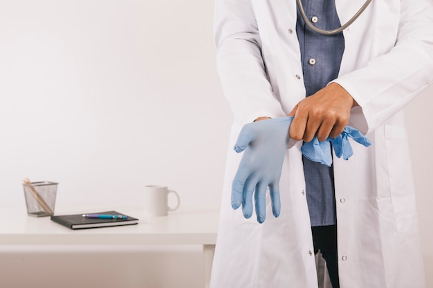 Médecin professionnel portant des gants à son bureau