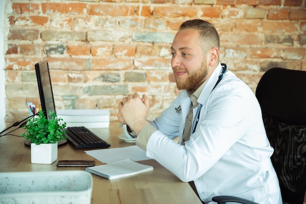 Médecin de race blanche consultant pour un patient travaillant au cabinet