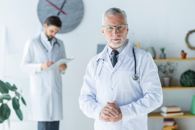 Médecin sénior positif au bureau