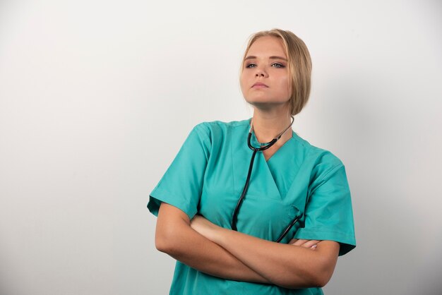 Médecin sérieux posant sur blanc.