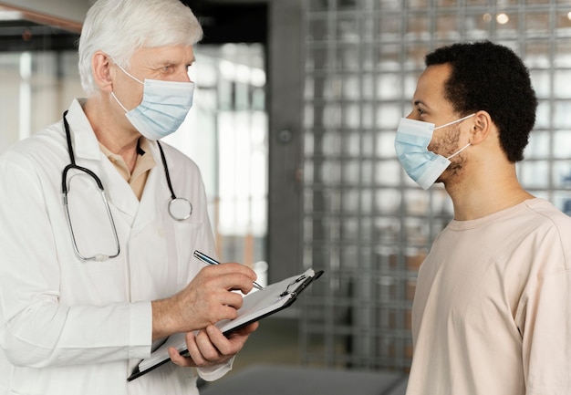 Médecin de sexe masculin, parler avec le patient