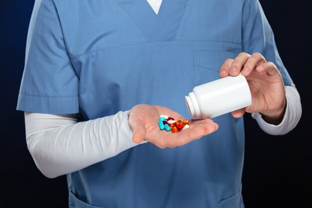 médecin de sexe masculin avec des pilules à la main