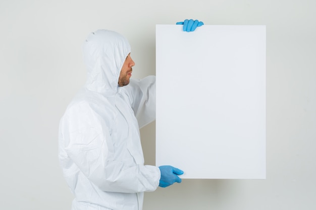 Médecin de sexe masculin regardant tableau blanc en tenue de protection