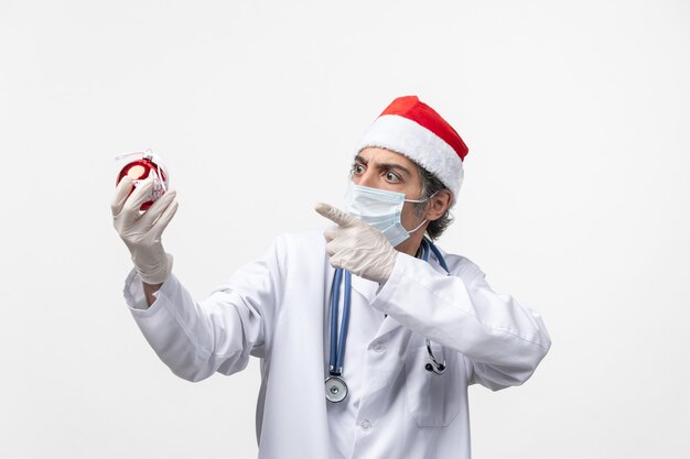 Médecin de sexe masculin tenant le virus covid de santé de jouet arbre du nouvel an