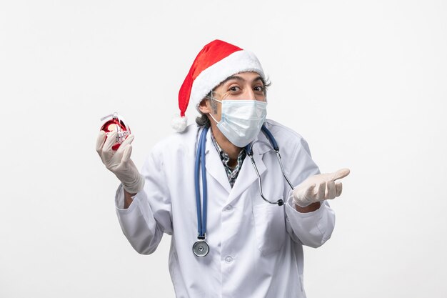 Médecin de sexe masculin tenant le virus covid de santé de plancher de jouet d'arbre de nouvel an