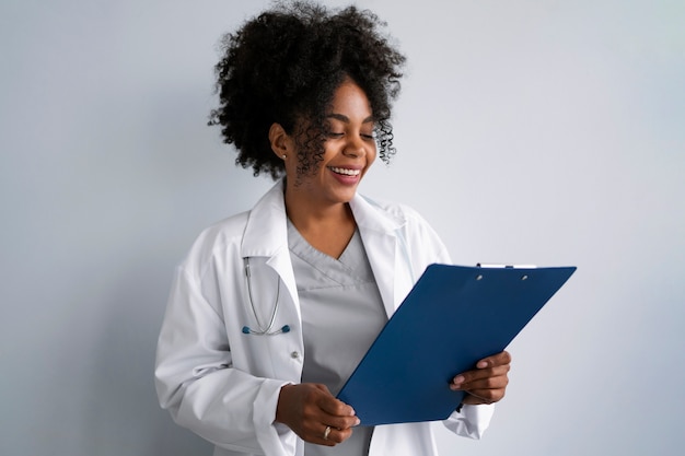 Médecin souriant à coup moyen vêtu d'un manteau blanc