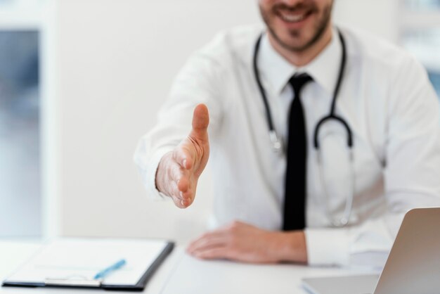 Médecin souriant de gros plan au travail