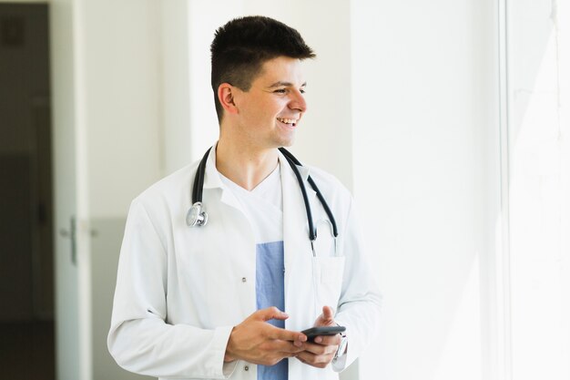 Médecin souriant avec smartphone