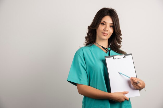 Médecin souriant avec stéthoscope montrant de bonnes nouvelles.