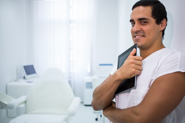 Médecin souriant tenant une tablette numérique à la clinique