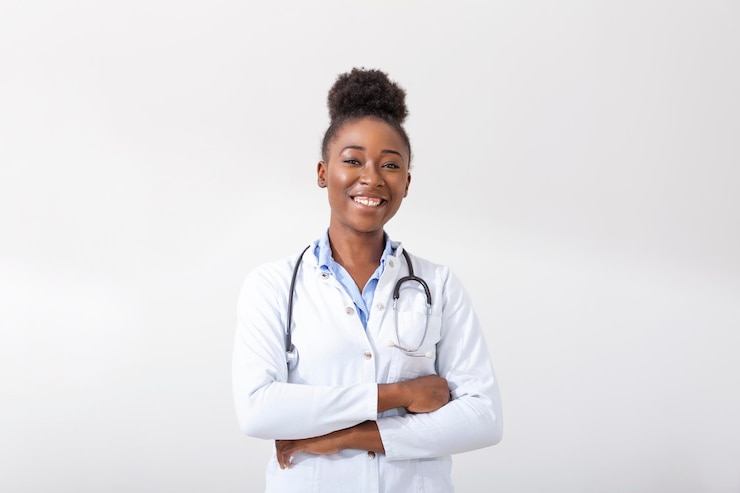 Photo gratuit médecin avec un stéthoscope main dans sa poche gros plan d'une femme souriante en se tenant droit sur fond blanc