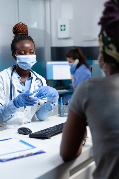 Médecin thérapeute afro-américain discutant avec un patient malade