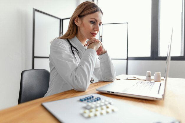 Médecin de tir moyen avec ordinateur portable