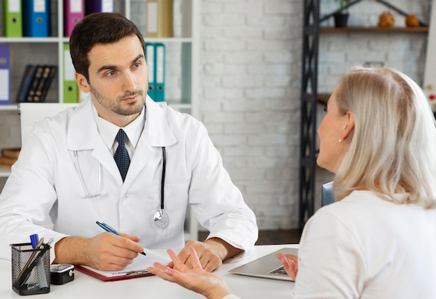 Médecin de tir moyen parlant au patient