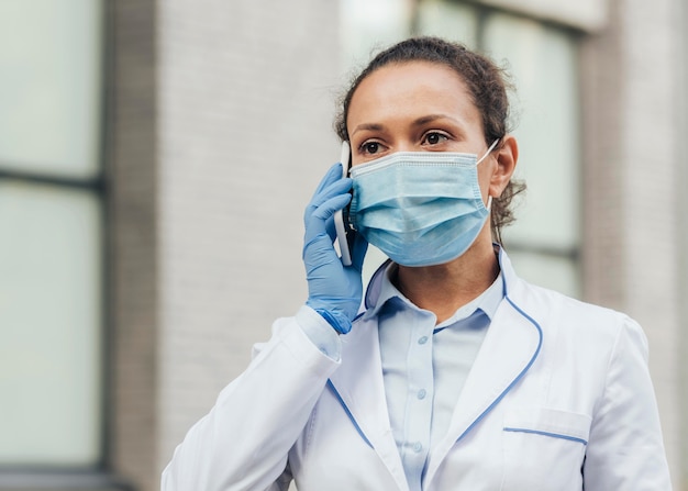 Médecin de tir moyen parlant au téléphone