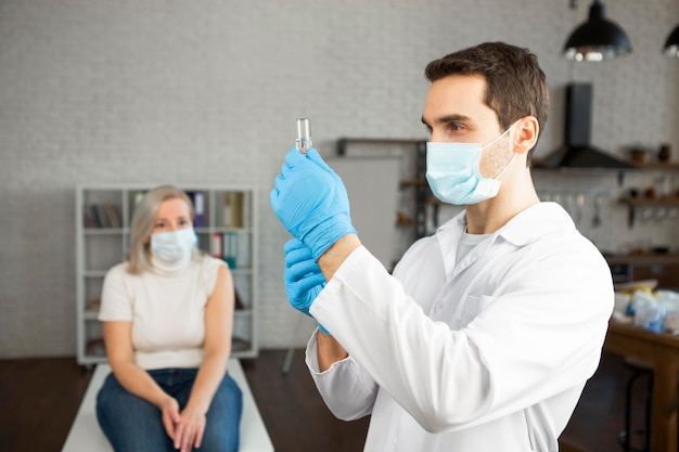 Photo gratuite médecin de tir moyen préparant le vaccin