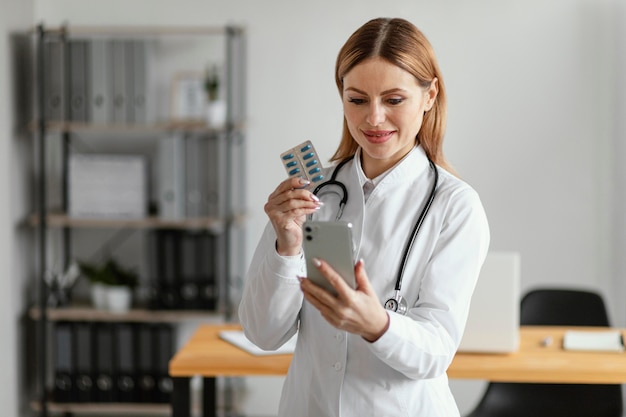 Photo gratuite médecin de tir moyen tenant des pilules