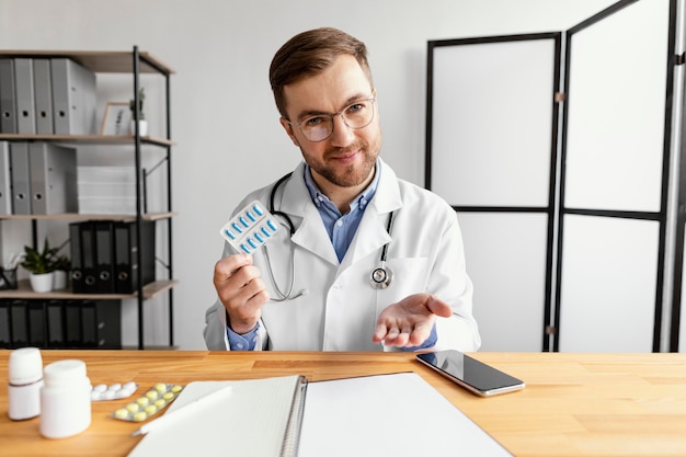 Photo gratuite médecin de tir moyen tenant des pilules