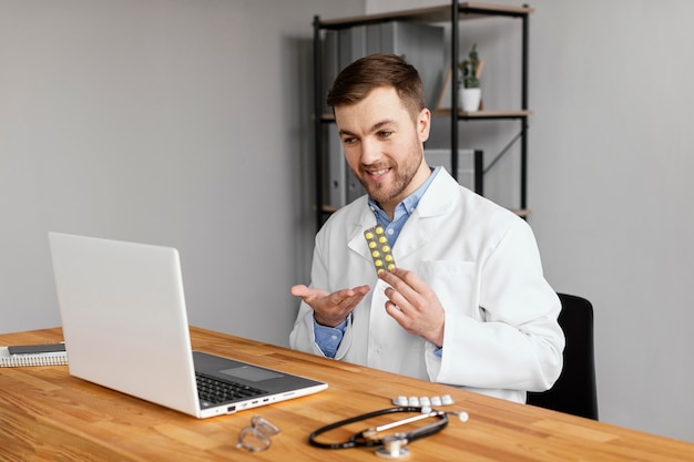 Photo gratuite médecin de tir moyen tenant des pilules