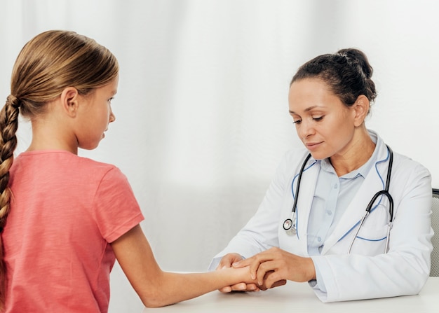 Photo gratuite médecin de tir moyen vérifiant fille