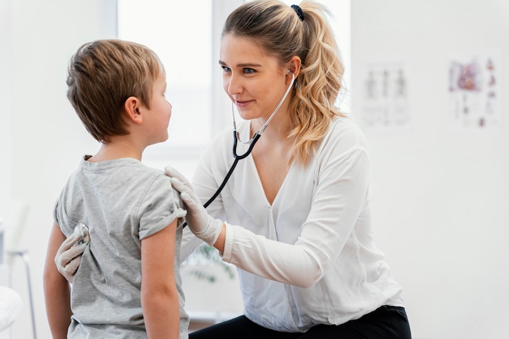 Photo gratuit médecin de tir moyen vérifiant kid