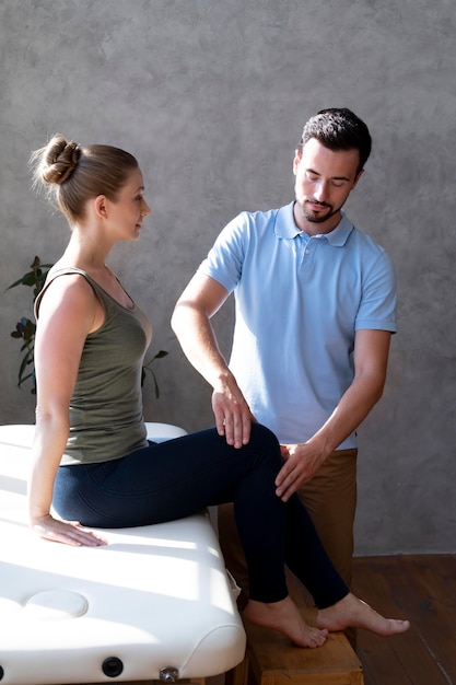 Photo gratuite médecin de tir moyen vérifiant le patient