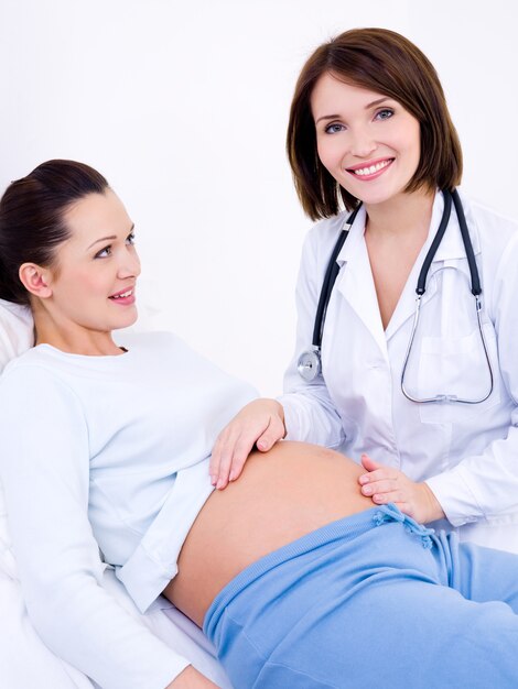 Médecin touche le ventre d'une femme enceinte