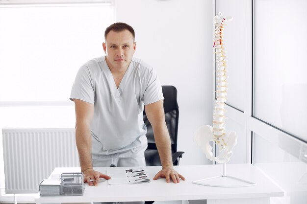 Médecin en uniforme blanc au bureau