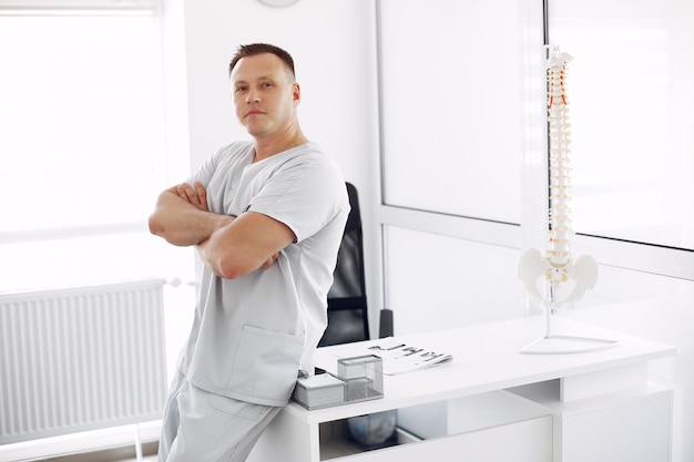 Médecin en uniforme blanc au bureau