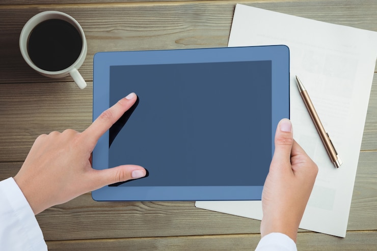 Photo gratuit le médecin utilise sa tablette avec le fond d'une tasse de café