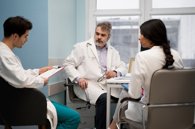 Photo gratuite médecins à coup moyen assis sur des chaises